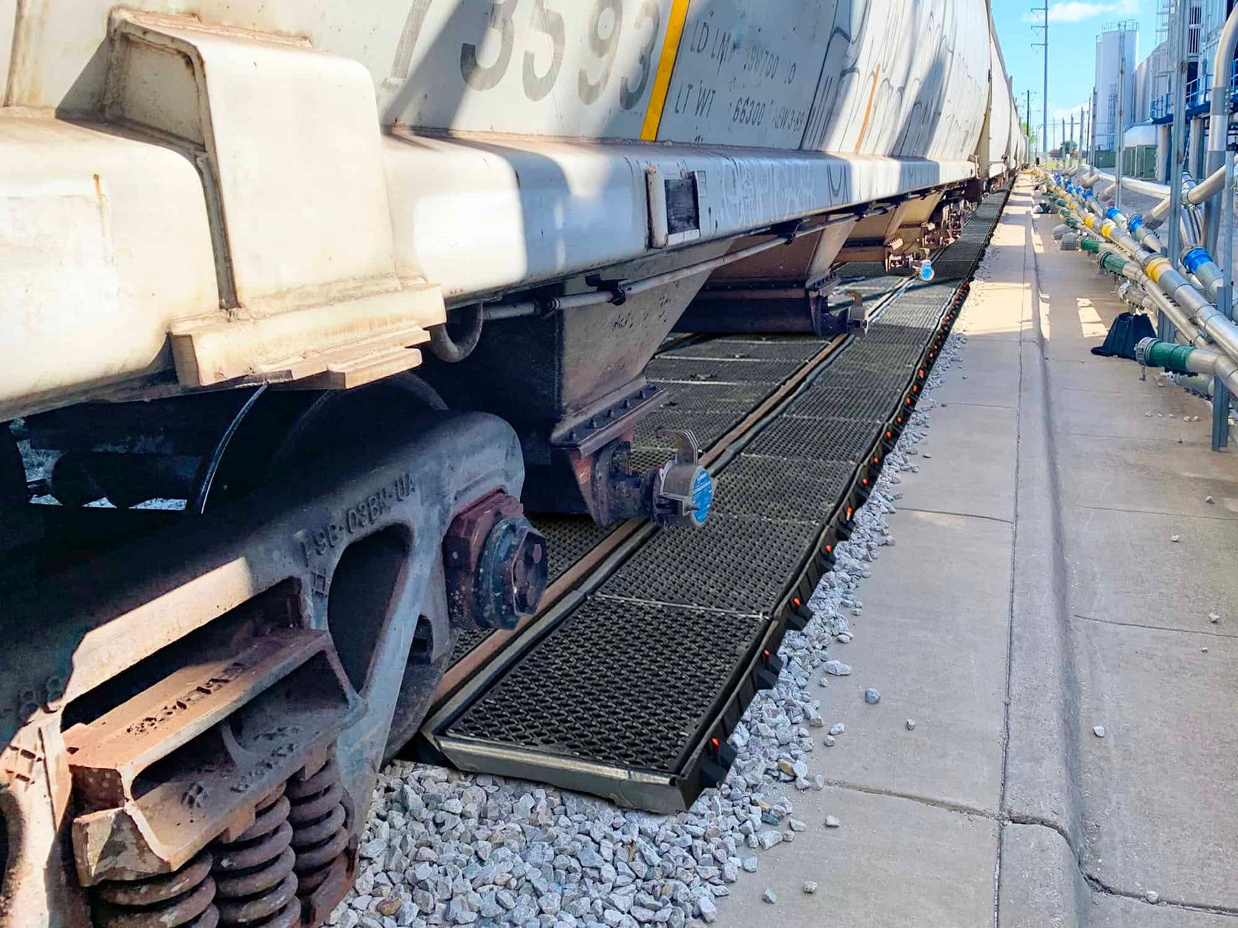 Ultra-Pellet Pans installed between and beside rails at a hopper car unloading spur