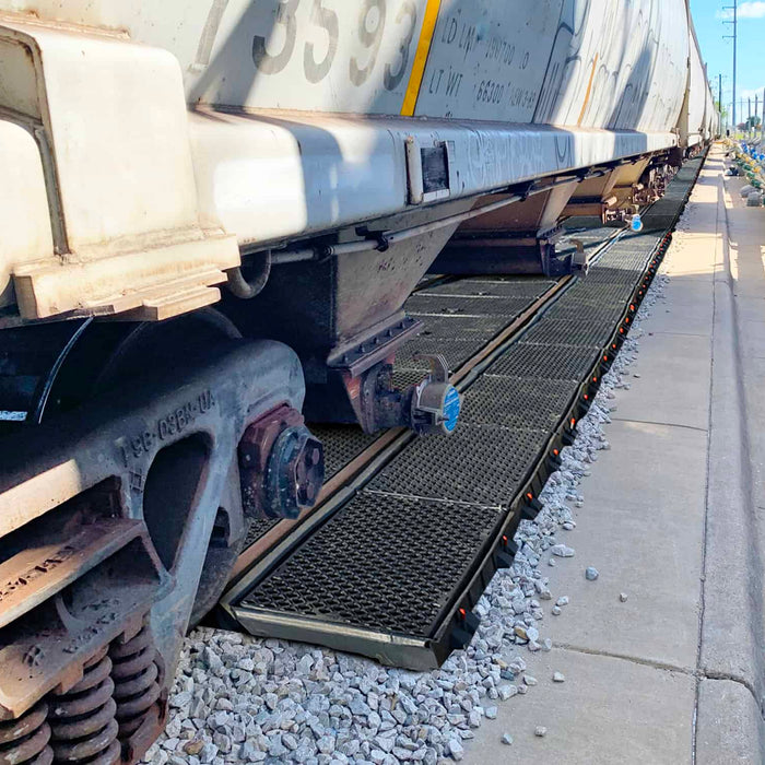 Ultra-Pellet Pans installed between and beside rails at a hopper car unloading spur